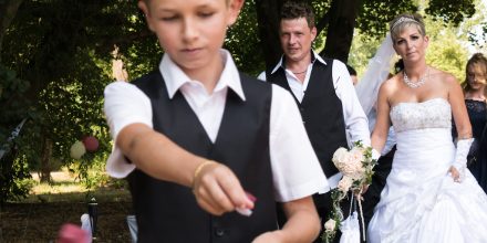 Hochzeitsfotografie Frisch vermähltes Brautpaar mit Blumenjunge